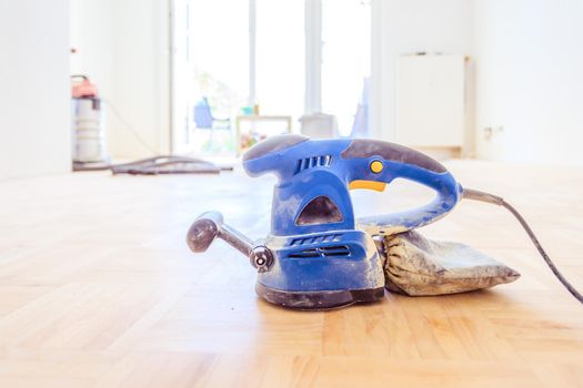 Close up of a sander power tool for DIY on wooden parquet floor