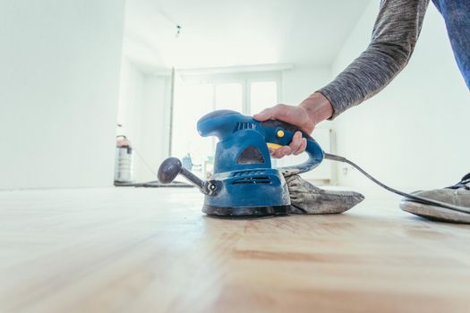Close up of a sander power tool for DIY on wooden parquet floor