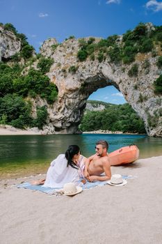 couple on vacation in the Ardeche France , young men and woman visiting Narural arch in Vallon Pont D'arc in Ardeche canyon in France. Europe