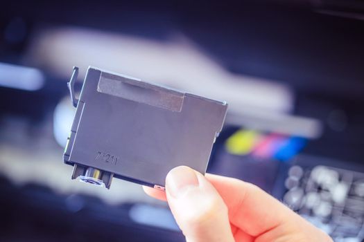Putting new printer cartridge into the printer, inkjet.