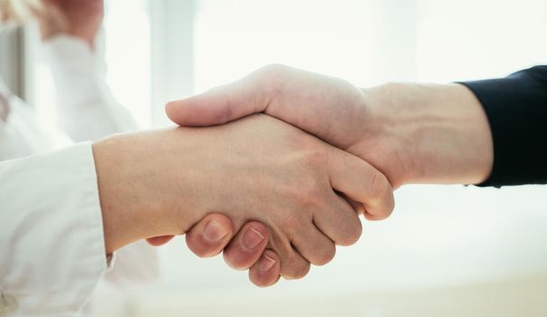 Man and woman are shaking hands, close up image, concept for human relationships