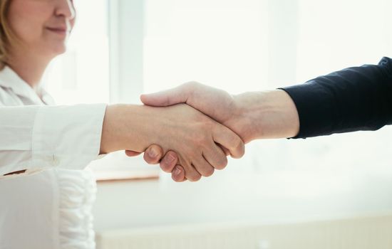 Man and woman are shaking hands, close up image, concept for human relationships