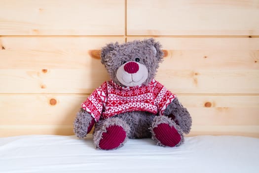 Cute teddy bear toy is sitting in the bed, wakeup at morning
