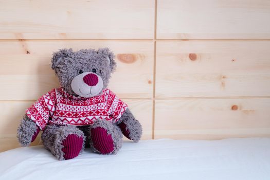 Cute teddy bear toy is sitting in the bed, wakeup at morning
