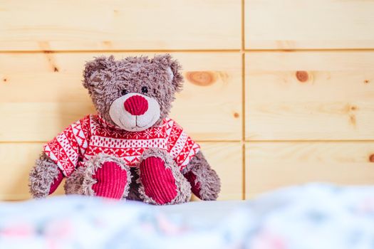 Cute teddy bear toy is sitting in the bed, wakeup at morning