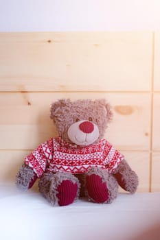 Cute teddy bear toy is sitting in the bed, wakeup at morning, sunlight