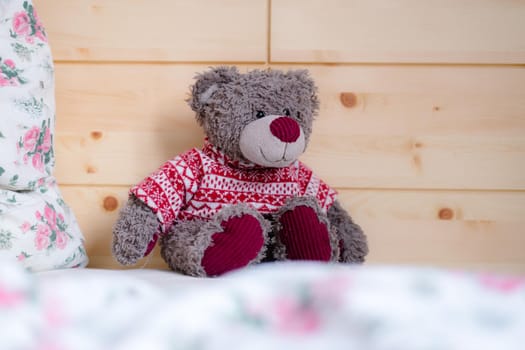 Cute teddy bear toy is sitting in the bed, wakeup at morning