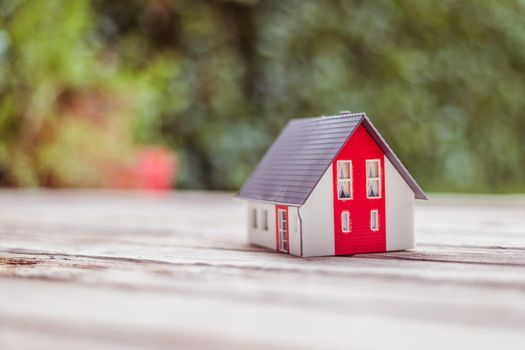 Red house model on the floor, outdoors. Concept for new home, property and estate