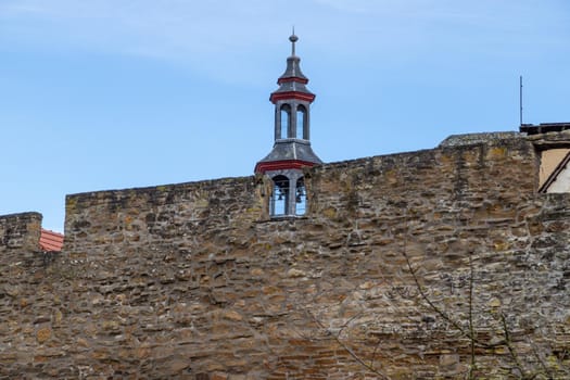 Part of the historic city wall with bell tower in the background in Meisenheim, Germany