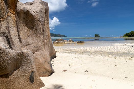 Beautiful beach Anse Source D'Argent on Seychelles island La Digue with white sand, blue water, granite rocks on the beach and blue sky with white clouds