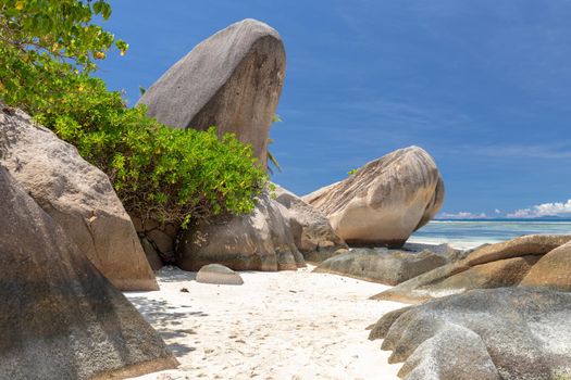 Beautiful beach Anse Source D'Argent on Seychelles island La Digue with white sand, blue water, granite rocks on the beach and blue sky with white clouds