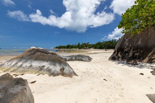 Beautiful beach Anse Source D'Argent on Seychelles island La Digue with white sand, blue water, granite rocks on the beach and blue sky with white clouds