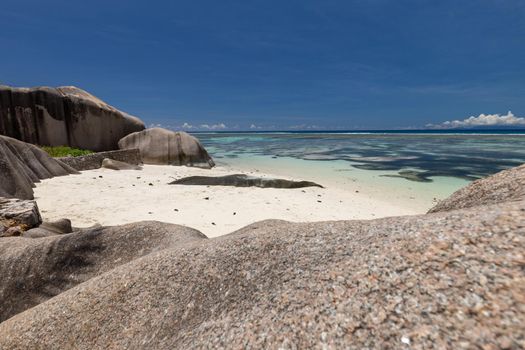 Beautiful beach Anse Source D'Argent on Seychelles island La Digue with white sand, blue water, granite rocks on the beach and blue sky with white clouds