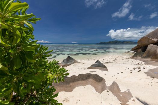 Beautiful beach Anse Source D'Argent on Seychelles island La Digue with white sand, blue water, granite rocks on the beach and blue sky with white clouds