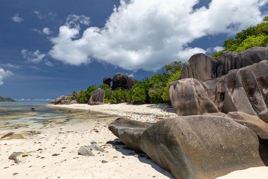 Beautiful beach Anse Source D'Argent on Seychelles island La Digue with white sand, blue water, granite rocks on the beach and blue sky with white clouds