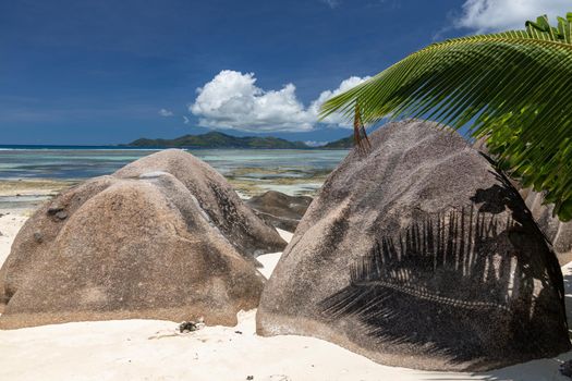 Beautiful beach Anse Source D'Argent on Seychelles island La Digue with white sand, blue water, granite rocks on the beach and blue sky with white clouds