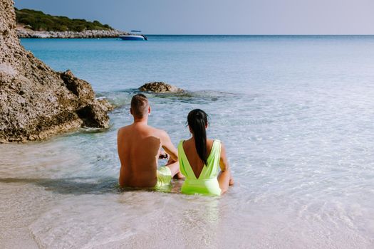 Tropical beach of Voulisma beach, Istron, Crete, Greece ,Most beautiful beaches of Crete island -Istron bay near Agios Nikolaos young couple mid age on vacation in Greece Crete