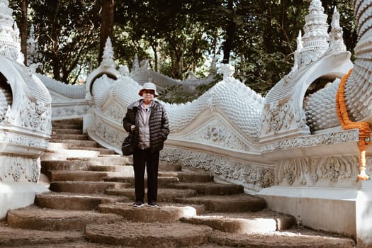old elderly female elder woman traveller traveling in asian temple. senior leisure lifestyle