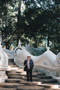 old elderly female elder woman traveller traveling in asian temple. senior leisure lifestyle