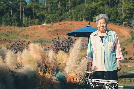 asian old elder woman elderly female relaxing resting on terrace balcony. senior leisure lifestyle