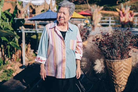 asian old elder woman elderly female relaxing resting on terrace balcony. senior leisure lifestyle