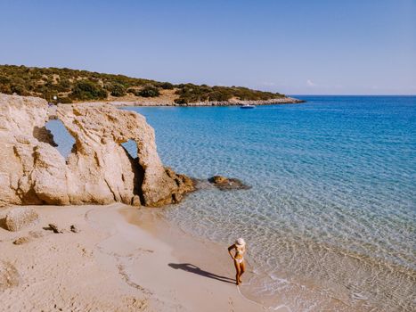 Tropical beach of Voulisma beach, Istron, Crete, Greece ,Most beautiful beaches of Crete island -Istron bay near Agios Nikolaos drone aerial view, woman in swimsuit on the beach