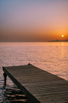  wooden pier at the beach in sunrise time with golden sky. Vacation and travel concept. Crete Greece