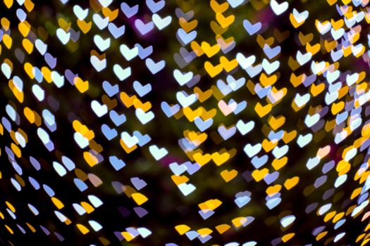 gold yellow blur heart shape love valentine day night light on tree in garden