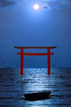 full moon on night sky over torii and silhouette birds flying and fishing boat on the sea