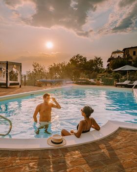 Luxury country house with swimming pool in Italy. Pool and old farm house during sunset central Italy. Couple on Vacation at luxury villa in Italy, men and woman watching sunset