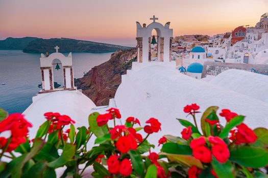 Sunset at the Island Of Santorini Greece, beautiful whitewashed village Oia with church and windmill during sunset, streets of Oia Santorini during summer vacation at the Greek Island