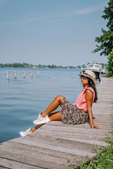 people relaxing in the park by the lake in the Netherlands Vinkeveen near Amsterdam, Vinkeveen is mainly famous for the Vinkeveense Plassen Lakes of Vinkeveen, an area of lakes and sand islands east of the village. It is an important recreational area Netherlands. Europe