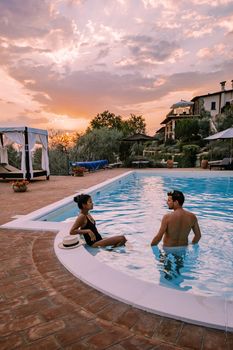 Luxury country house with swimming pool in Italy. Pool and old farm house during sunset central Italy. Couple on Vacation at luxury villa in Italy, men and woman watching sunset