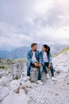 couple hiking in the italian dolomites during foggy weather with clouds, Stunning view to Tre Cime peaks in Dolomites, Italy. Europe