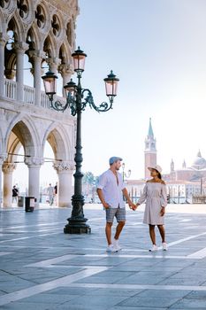 couple on a city trip in Venice, view of piazza San Marco, Doge's Palace Palazzo Ducale in Venice, Italy. Architecture and landmark of Venice. Sunrise cityscape of Venice Italy