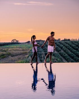 Luxury resort with a view over the wine field in Selinunte Sicily Italy. infinity pool with a view over wine fields in Sicilia, a couple on luxury vacation at the Island of Sicily Italy