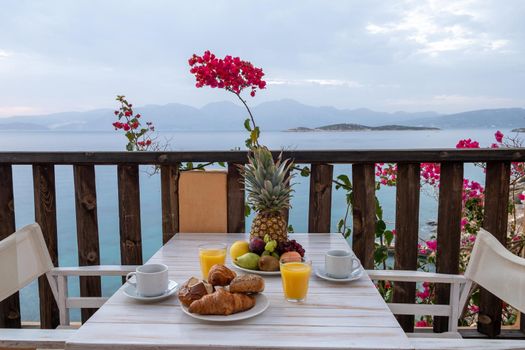 table and chairs with breakfast during sunrise at the meditarian sea in Greece. High quality photo