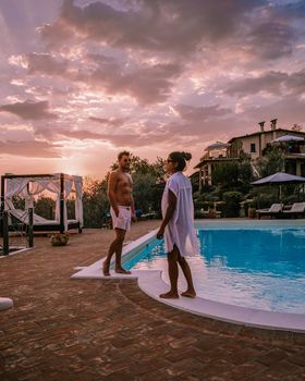 Luxury country house with swimming pool in Italy. Pool and old farm house during sunset central Italy. Couple on Vacation at luxury villa in Italy, men and woman watching sunset