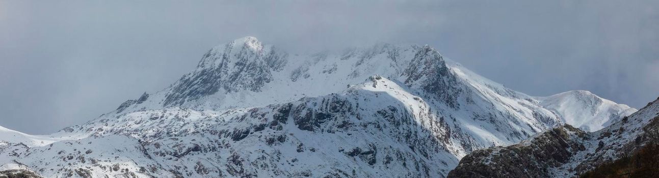 Panoramic landscape of snowy mountains in the Aragonese Pyrenees. Selva de Oza valley, Hecho and Anso, Huesca, Spain.