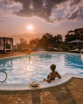 Luxury country house with swimming pool in Italy. Pool and old farm house during sunset central Italy. Couple on Vacation at luxury villa in Italy, men and woman watching sunset