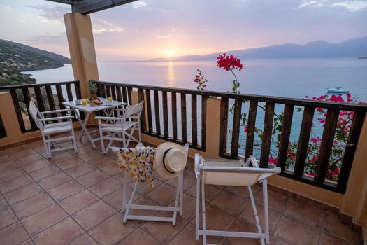 table and chairs with breakfast during sunrise at the meditarian sea in Greece. High quality photo