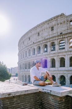 View of Colosseum in Rome and morning sun, Italy, Europe. young guy on city trip Rome