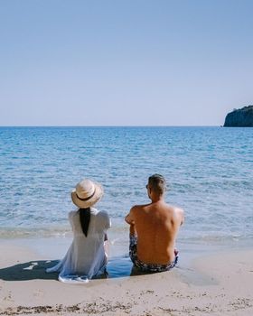 Tropical beach of Voulisma beach, Istron, Crete, Greece ,Most beautiful beaches of Crete island -Istron bay near Agios Nikolaos young couple mid age on vacation in Greece Crete