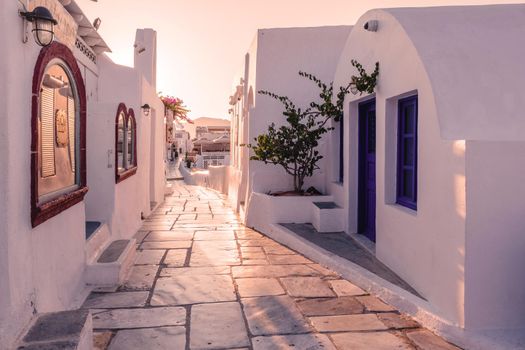 Sunset at the Island Of Santorini Greece, beautiful whitewashed village Oia with church and windmill during sunset, streets of Oia Santorini during summer vacation at the Greek Island