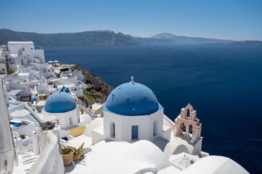 Sunset at the Island Of Santorini Greece, beautiful whitewashed village Oia with church and windmill during sunset, streets of Oia Santorini during summer vacation at the Greek Island