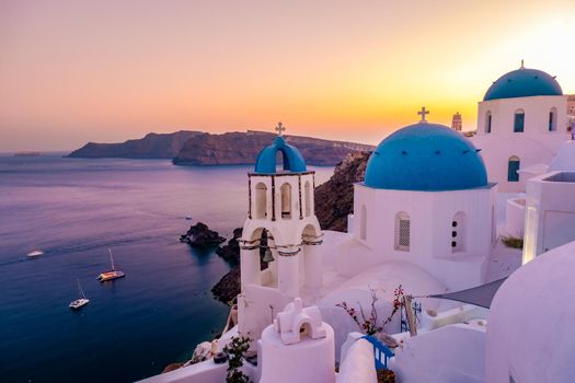 Sunset at the Island Of Santorini Greece, beautiful whitewashed village Oia with church and windmill during sunset, streets of Oia Santorini during summer vacation at the Greek Island