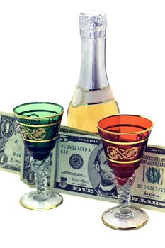 dollars in small denominations between colorful shot glasses and a bottle of wine