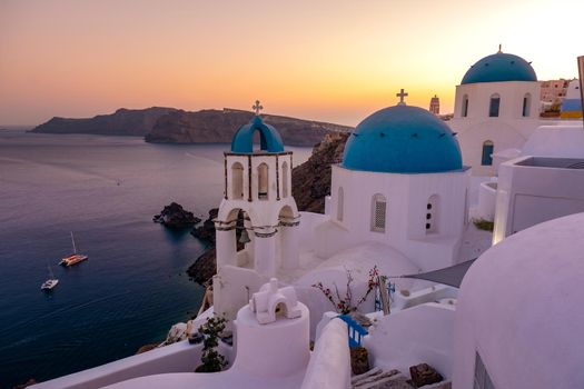 Sunset at the Island Of Santorini Greece, beautiful whitewashed village Oia with church and windmill during sunset, streets of Oia Santorini during summer vacation at the Greek Island