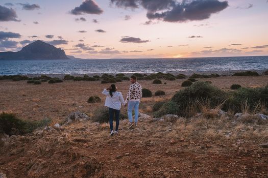 San Vito Lo Capo Sicilia, couple men and woman mid-age visiting the beach of San Vito Lo Capo Sicily Italy