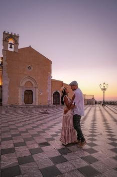 Taormina Sicily, Belvedere of Taormina and San Giuseppe church on the square Piazza IX Aprile in Taormina. Sicily, Italy. Couple on vacation at the Italian Island Sicily